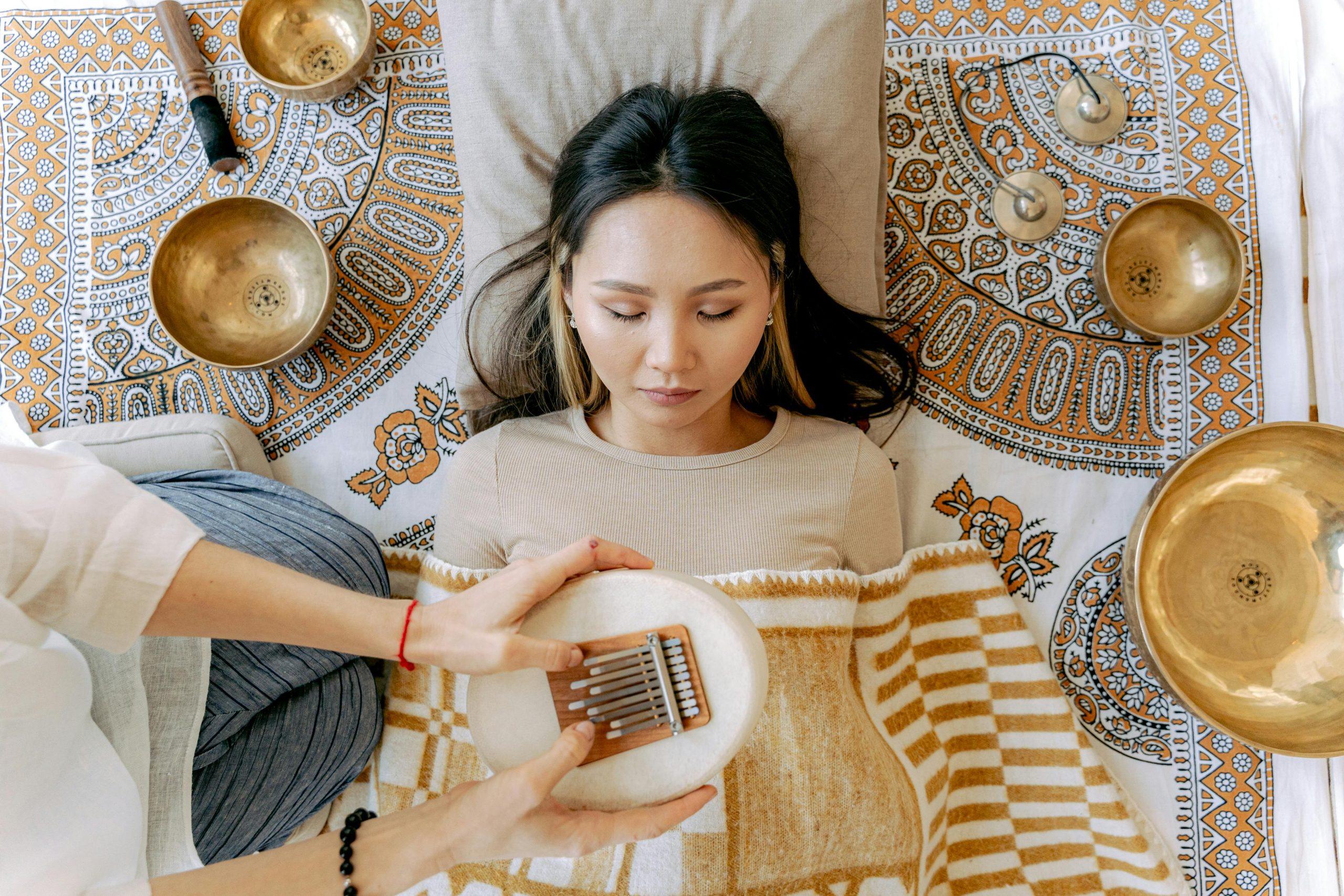 A serene meditation scene featuring a woman with kalimba and singing bowls, promoting relaxation and well-being.